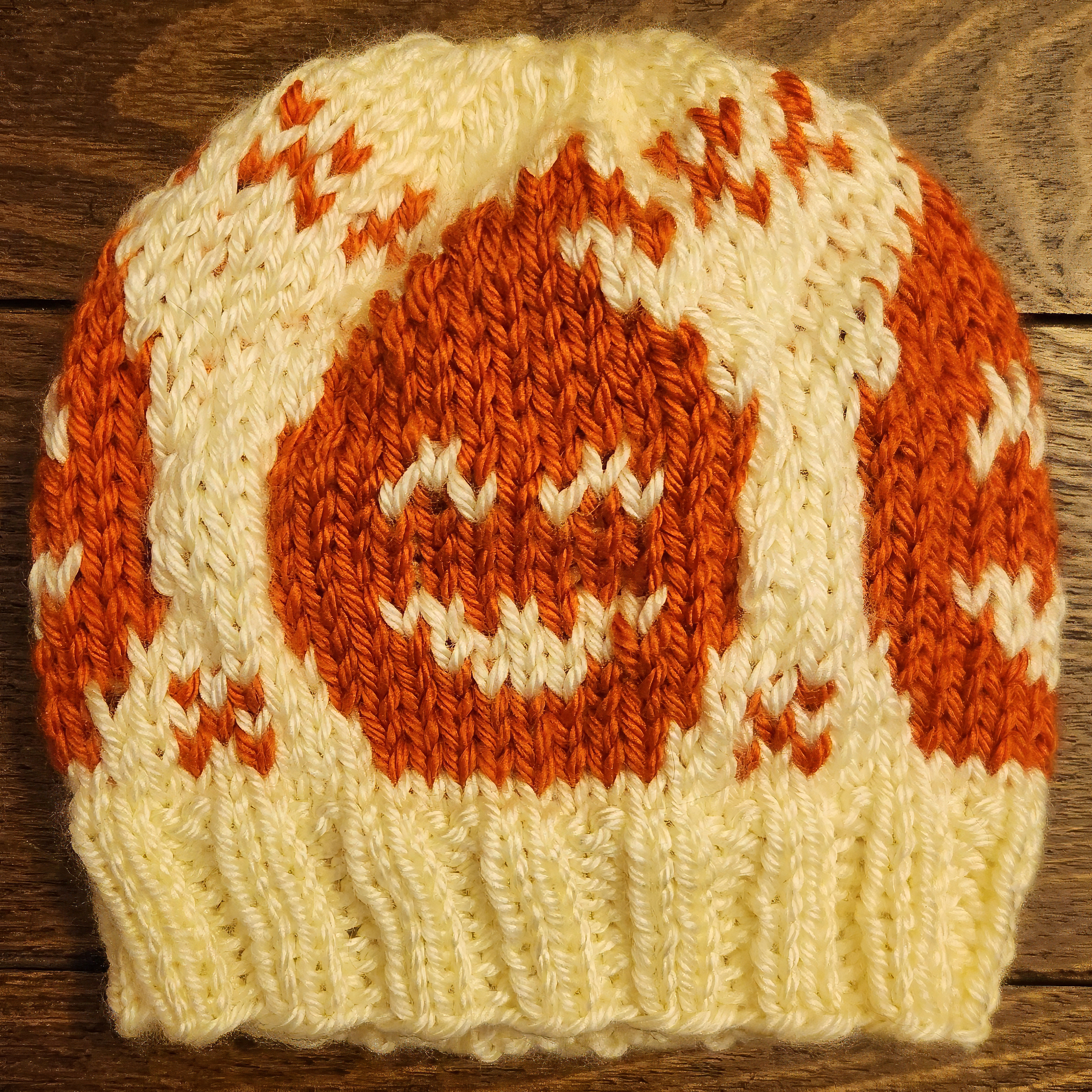Knit cream-white hat with Halloween/jack-o-lantern design going all the way around.